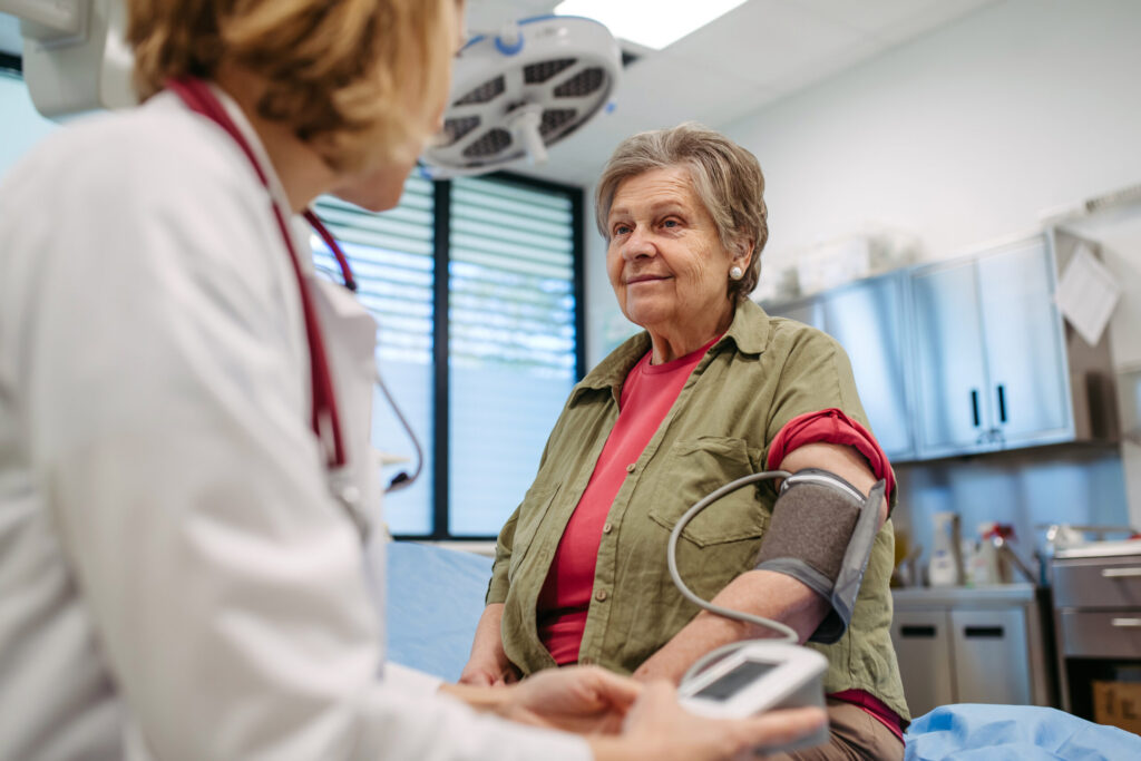 Senior woman having blood pressure checked during preventive medical exam