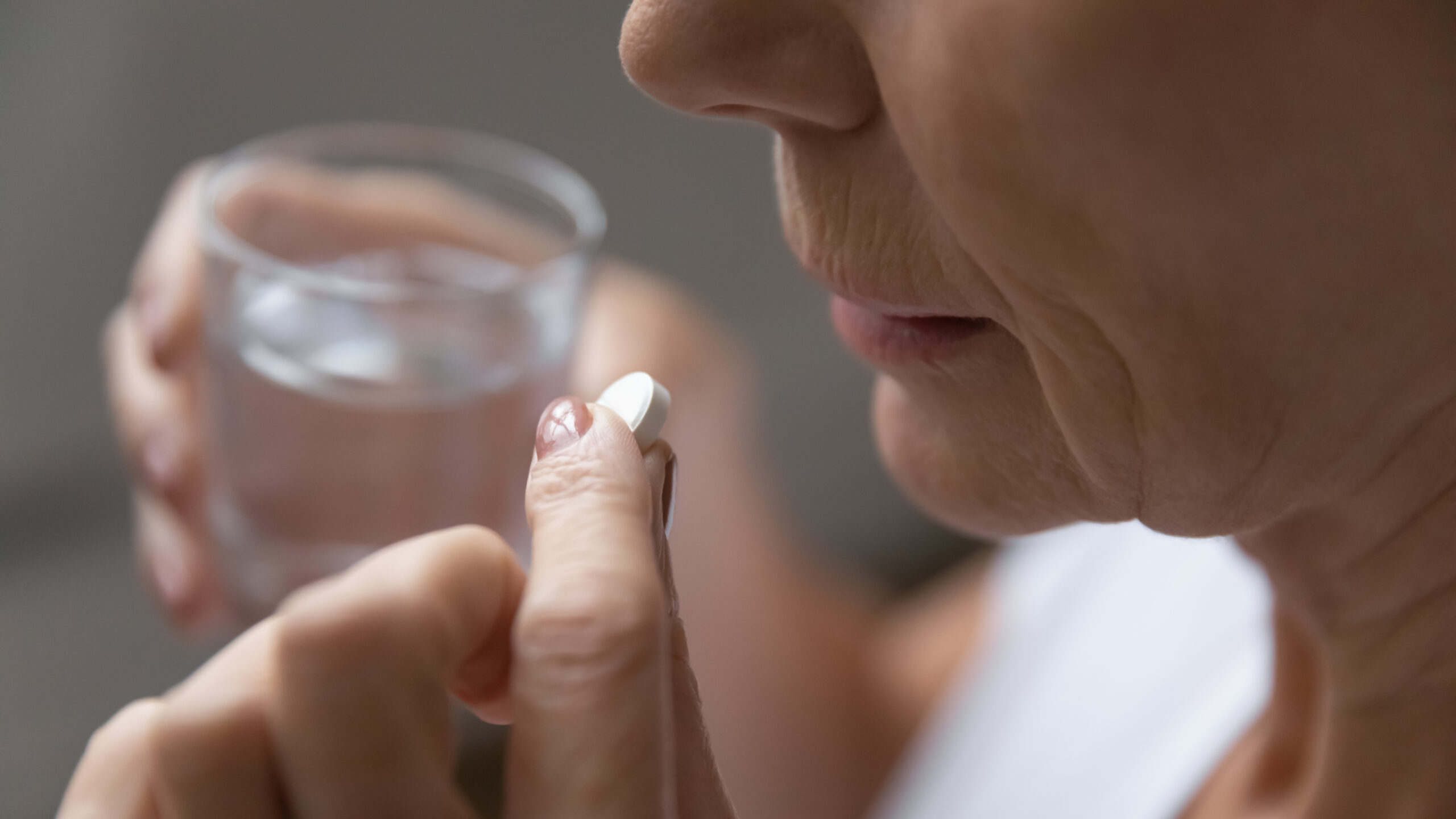 old woman taking aspirin